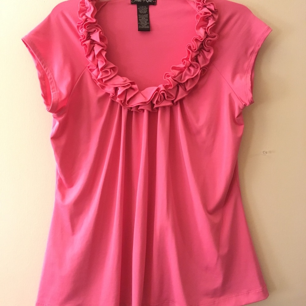 Pink top with ruffles outlining scoop neck